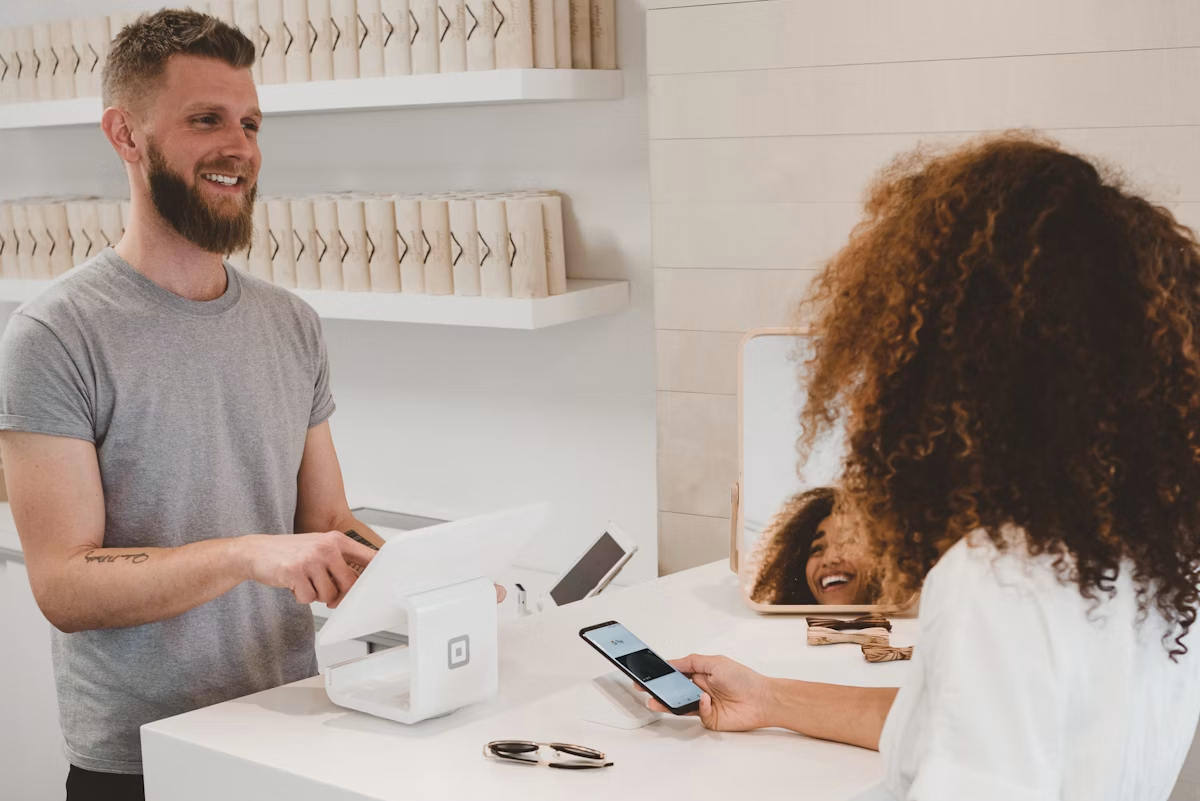 Shopper paying with a phone at a modern retail checkout counter